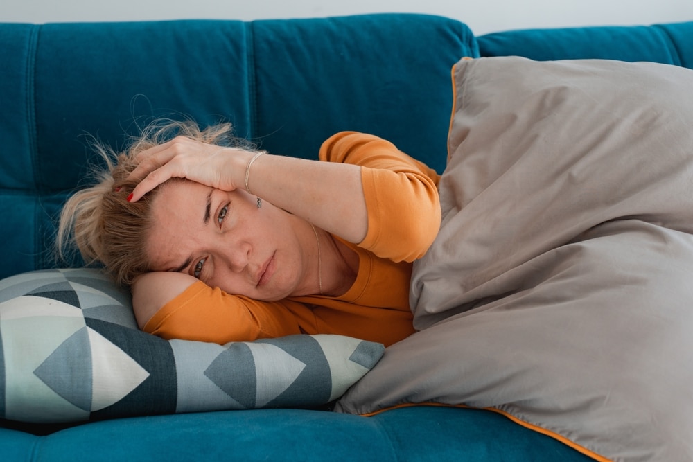 Woman who suffers from chronic illness felling unwell after having a bad night's sleep.