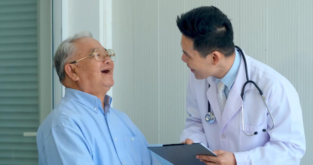Happy elderly man getting a routine checkup with his doctor