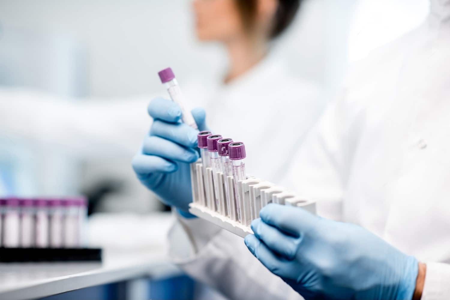 A doctor holding a tray of test tubes for medical laboratory testing