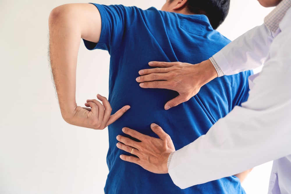 A chiropractor in Tysons Corner examining a patient’s back