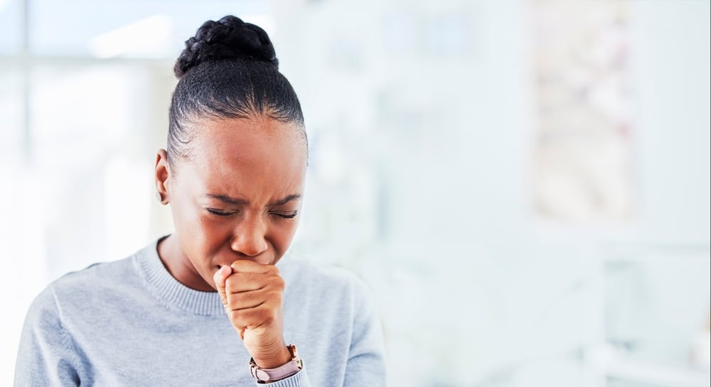 A woman with the flu coughing
