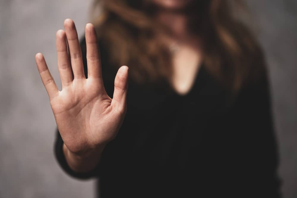 A woman holding up her hand saying no to food while taking blood thinners