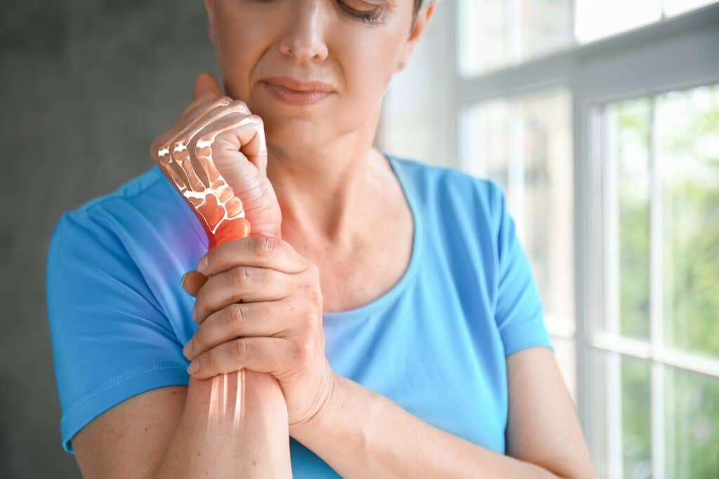 A woman with osteoporosis holding her wrist