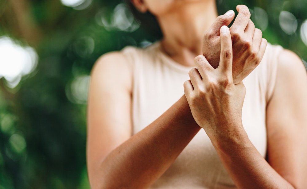 A woman with chronic pain holding her wrist