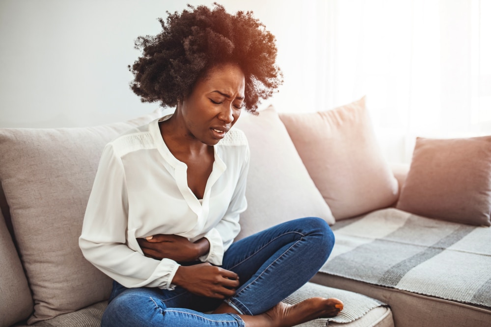 A woman with a stomach ulcer holding her stomach