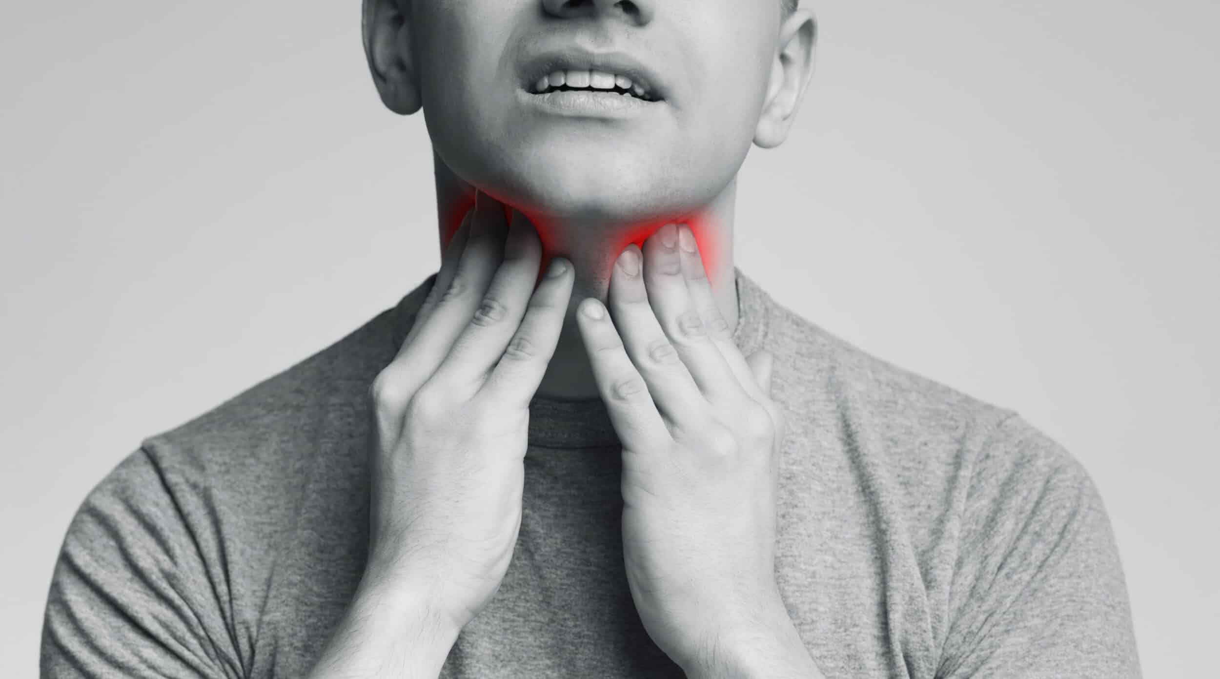 Man with thyroid gland problem, touching his neck, close up, panorama