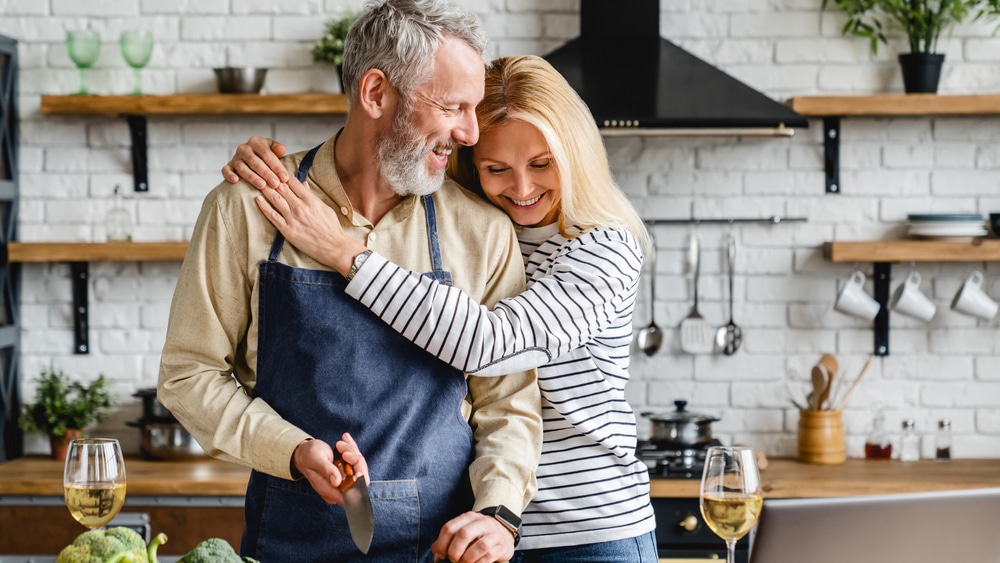 A couple hugging while cooking non-blood-thinning foods