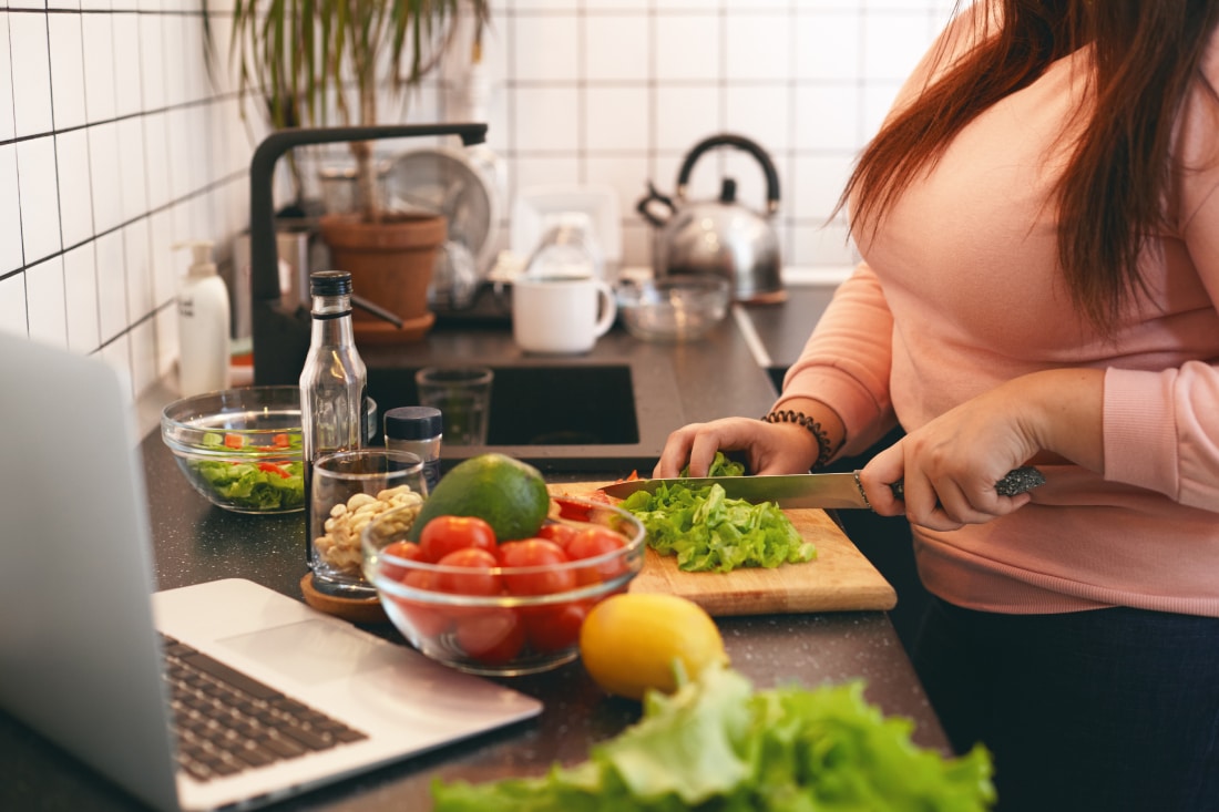 A woman chopping vegetables as part of a diet plan from Prima Medicine