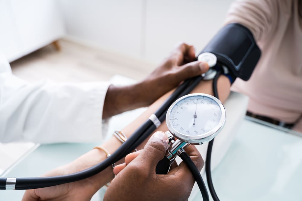 A close-up shot of a doctor taking a woman's blood pressure