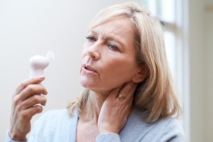 Woman experiencing a hot flash due to menopause in Fairfax Woman experiencing a hot flash due to menopause in Fairfax