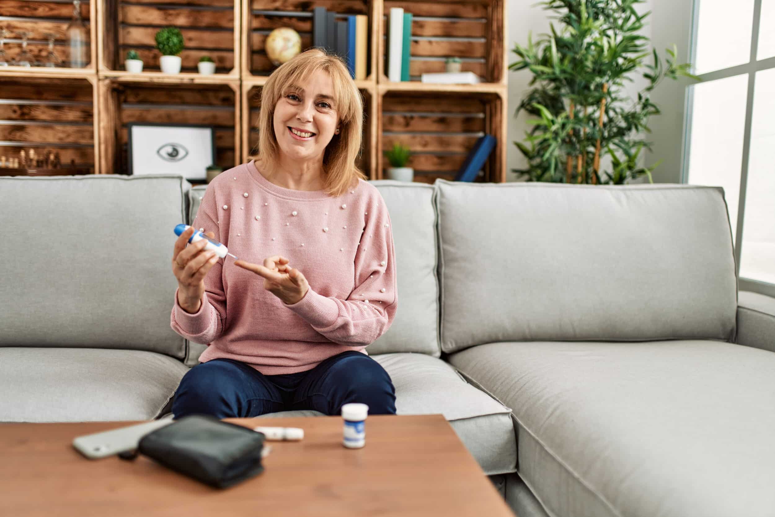 Middle age diabetic woman measuiring glucose using glucometer at home. A woman with diabetes testing her blood sugar