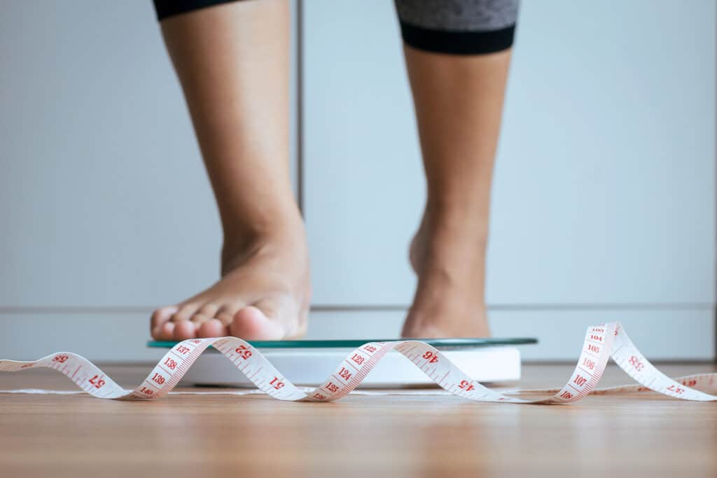 Person standing on scale, interested in semaglutide treatment for weight loss. Foundayo™ in Fairfax, South Riding, Merrifield & Tysons, VA