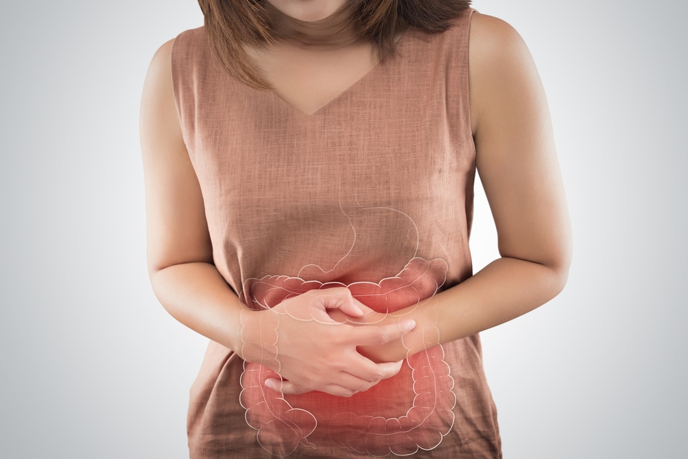 Woman with a peptic ulcer and diarrhea holding her stomach